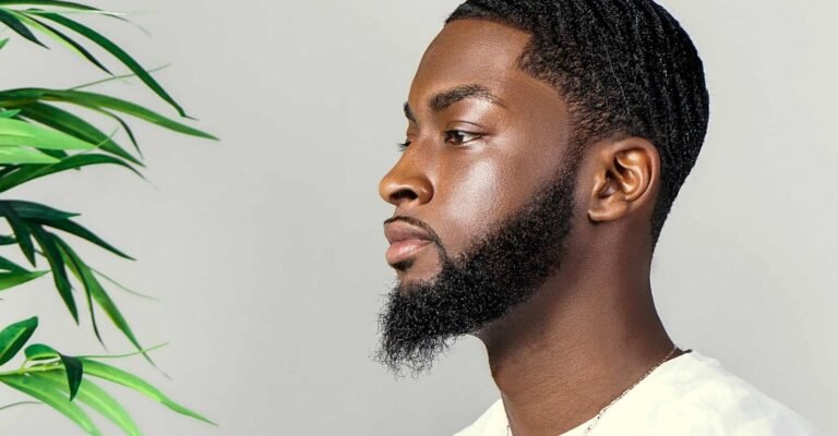 Side profile of a man with a clean line up haircut and well-groomed beard, showcasing precise hairline detailing.